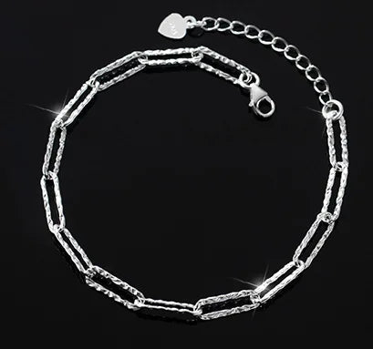 Armband aus 925er Sterlingsilber mit langen, strukturierten Gliedern, Karabinerverschluss und Verlängerungskette mit kleinem Herz-Anhänger.
925er Silberarmband mit unregelmäßig gehämmert aussehenden, rechteckigen Kettengliedern und einer funkelnden Oberfläche.