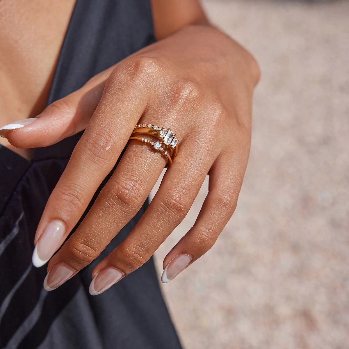  Nahaufnahme eines einzelnen goldenen Rings aus 18K vergoldetem Edelstahl mit einem prominenten, rechteckigen Zirkoniastein, getragen am Finger.