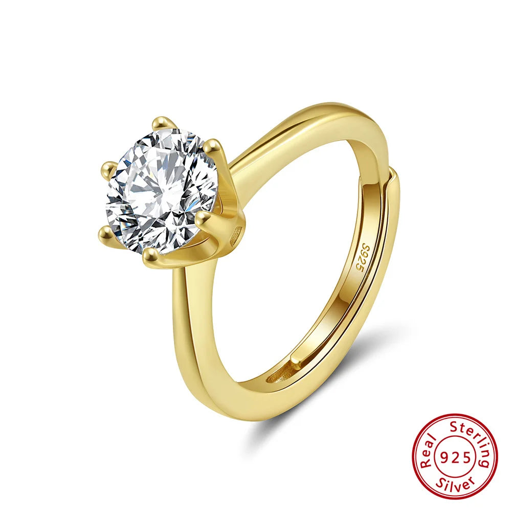 Freigestellter, verstellbarer Ring aus 14K vergoldetem 925er Sterling Silber, der einen großen, runden Zirkonia-Stein in Krappenfassung präsentiert. Das 'Real 925 Sterling Silver' Echtheitssiegel ist unten rechts erkennbar.