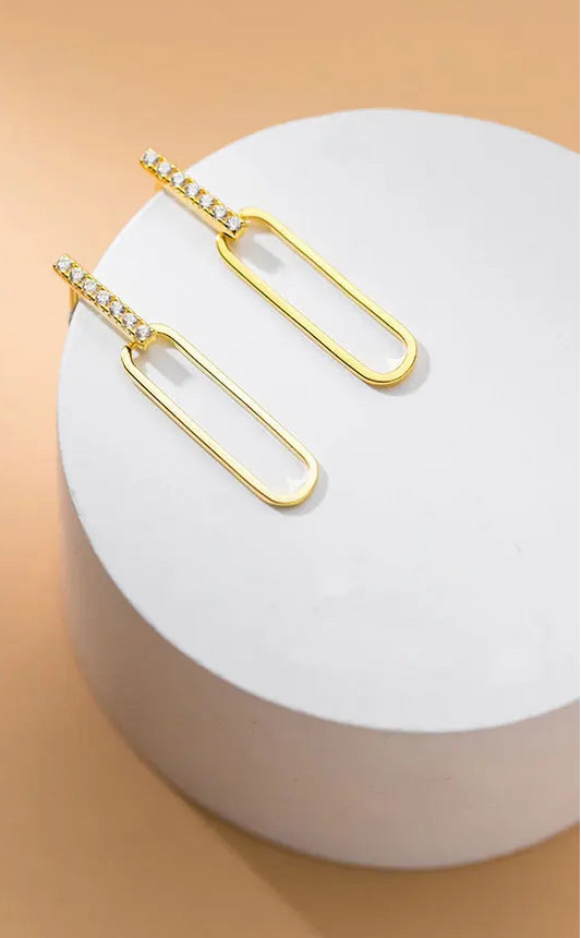 Produktansicht der 18K vergoldeten 925er Silber-Ohrstecker mit Zirkonia-Besatz auf einem weißen Dekopodester.