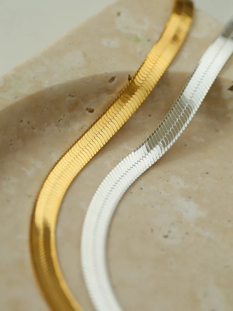 Detailansicht der flachen Schlangenketten in Gold und Silber | hochglänzende Unisex-Halskette | Kette glattes Herringbone-Design