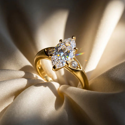 Eleganter Solitär-Verlobungsring aus 14K vergoldetem 925 Silber mit großem Zirkonia im Marquise-Schliff (Navette) und seitlichen Akzentsteinen auf sanft drapierter Seide