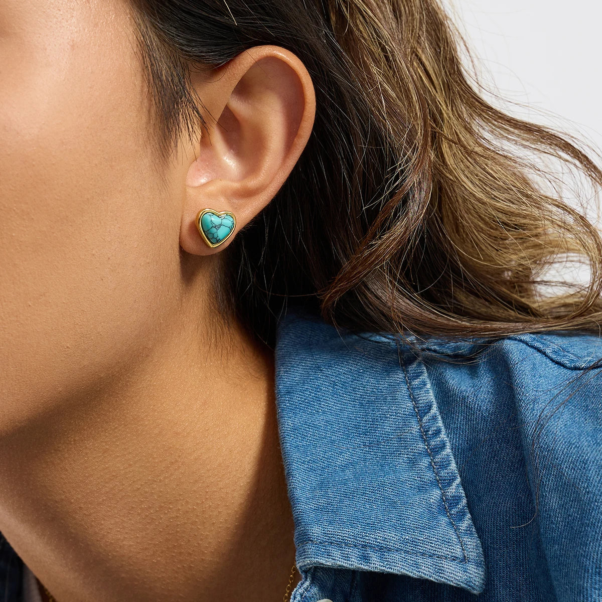 Seite des Herz-Ohrsteckers aus 18K vergoldetem Edelstahl mit blauem Türkisstein am Ohr einer Frau.