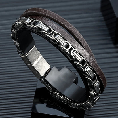 Dunkelbraunes Mikrofaser-Lederarmband für Männer, kombiniert mit einer markanten, geschwärzten Edelstahlkette im Biker-Stil, schräg präsentiert.