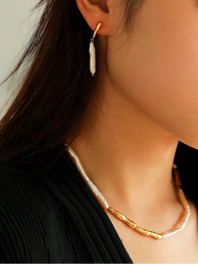 Elegantes Schmuckset bestehend aus Halskette, Armband und Ohrhängern, gefertigt aus unregelmäßigen Barockperlen und 18K vergoldeten Messing-Elementen.