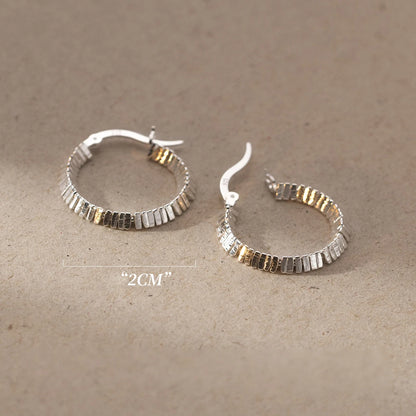 Zwei strukturierte Kreolen-Ohrringe (925er Silber) liegen nebeneinander, mit einem sichtbaren Maßband zur Größenbestimmung.

