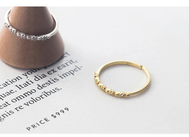 Filigrane vergoldete Ringe mit Zirkonia-Besatz stilvoll auf Magazin-Papier präsentiert