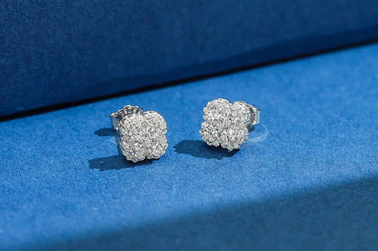 Freisteller eines Paares silberfarbener Kleeblatt-Ohrstecker aus reinem 925er Sterling Silber, dicht besetzt mit funkelnden Zirkonia-Steinen. Unten rechts ist das 'Real 925 Sterling Silver' Siegel erkennbar.