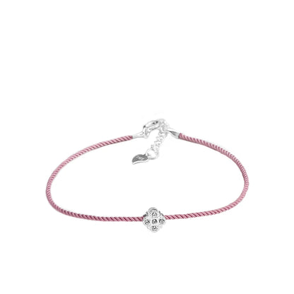 Armband mit zartrosa Textilband und einem kleinen, runden Anhänger aus 925er Silber mit einem zentralen Zirkoniastein. Das Armband hat einen verstellbaren 925er Silber-Verschluss mit einem kleinen Herz-Anhänger.