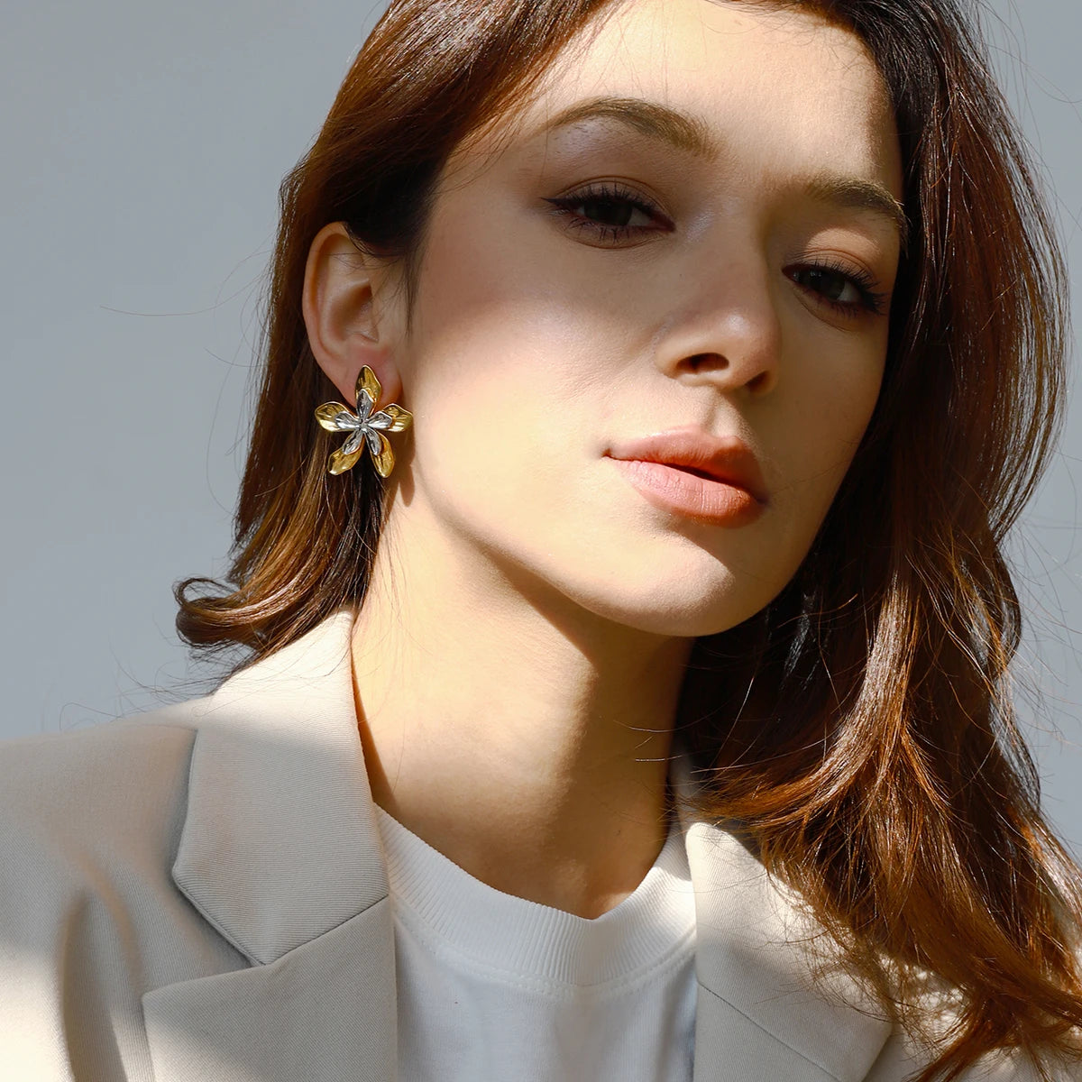 Goldene Blumen-Ohrstecker aus PVD 18K vergoldetem Edelstahl getragen von Model | floraler Ohrschmuck