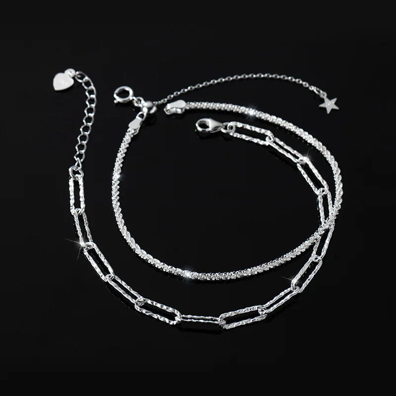 Doppelreihiges Armband/Fußkette aus 925er Silber (eine feingliedrige und eine längliche Gliederkette) liegt auf schwarzem Hintergrund. Es ist ein verstellbarer Verschluss mit einem kleinen Stern-Anhänger sichtbar.