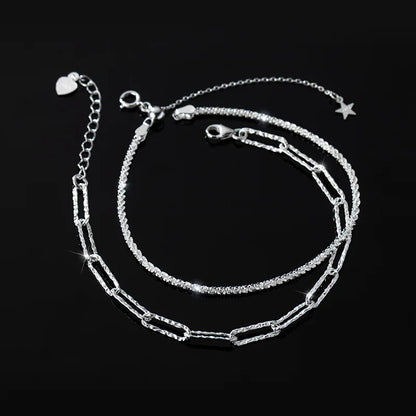Doppelreihiges Armband/Fußkette aus 925er Silber (eine feingliedrige und eine längliche Gliederkette) liegt auf schwarzem Hintergrund. Es ist ein verstellbarer Verschluss mit einem kleinen Stern-Anhänger sichtbar.