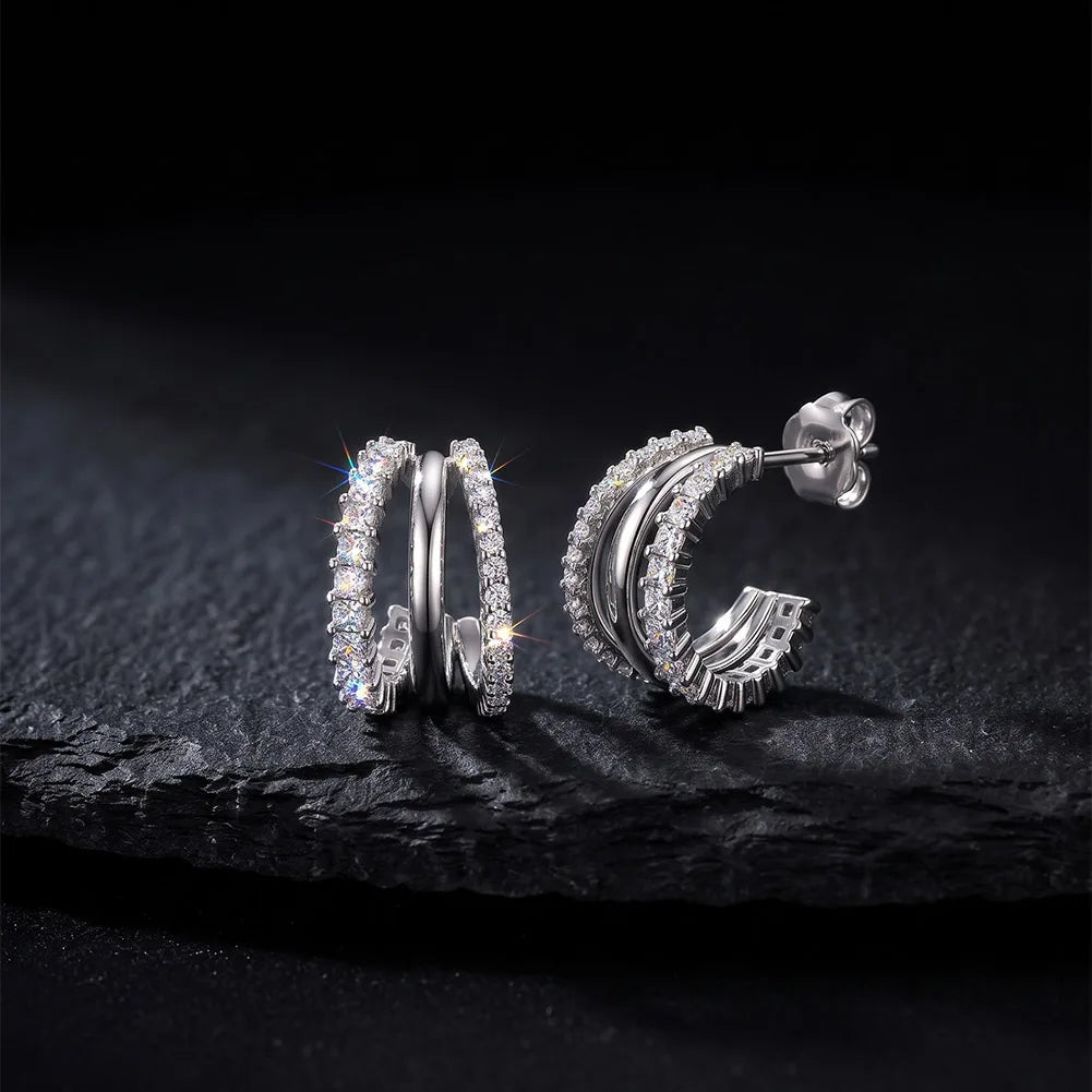 Dreireihige Zirkonia-Creolen aus 925 Sterling Silber im Huggie-Look mit Schmetterlingsverschluss auf schwarzem Steinuntergrund