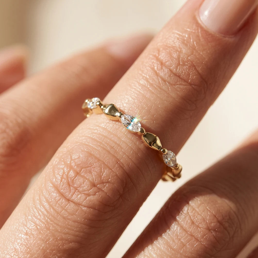 Nahaufnahme am Finger: Schmaler Memory-Ring aus 14K vergoldetem 925 Silber im Wechseldesign aus rautenförmigen Elementen und funkelnden Marquise-Zirkoniasteinen.