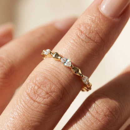 Nahaufnahme am Finger: Schmaler Memory-Ring aus 14K vergoldetem 925 Silber im Wechseldesign aus rautenförmigen Elementen und funkelnden Marquise-Zirkoniasteinen.