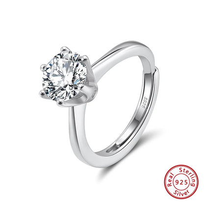 Freigestellter, verstellbarer Ring aus reinem 925er Sterling Silber, besetzt mit einem prominenten, runden Zirkonia-Stein in Krappenfassung. Das 'Real 925 Sterling Silver' Echtheitssiegel ist unten rechts erkennbar.