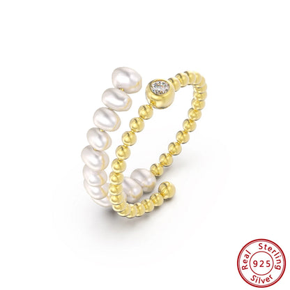 Freigestellter, 14K Gold vergoldeter Ring mit spiralförmig angeordneten Süßwasserperlen und Strass. Unten rechts: Siegel "Real 925 Sterling Silver".