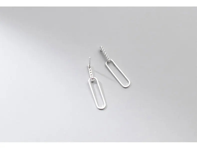 Schlichte Produktfotografie der silbernen 925er Sterling Silber-Ohrstecker mit Zirkonia-Steinen und ovalem Anhänger.