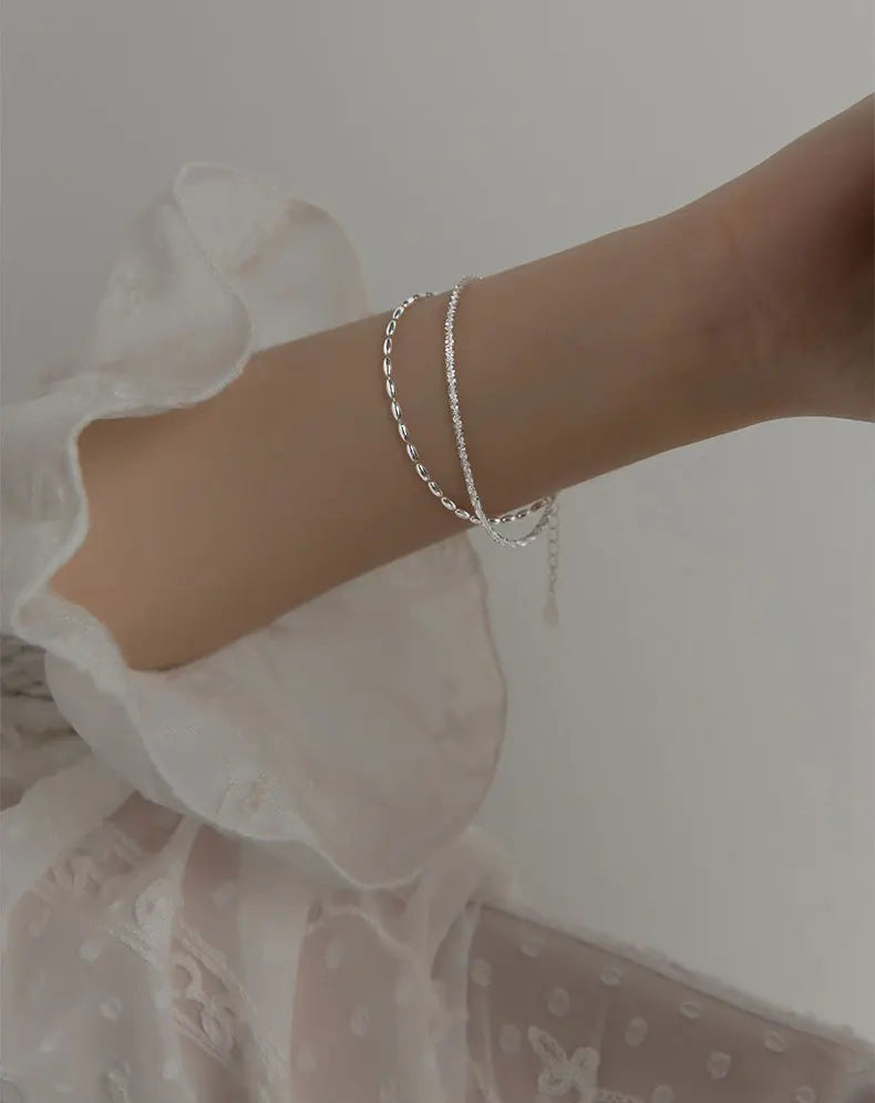 Dezente Trageansicht des mehrreihigen 925 Silberarmbands am Handgelenk einer Frau
