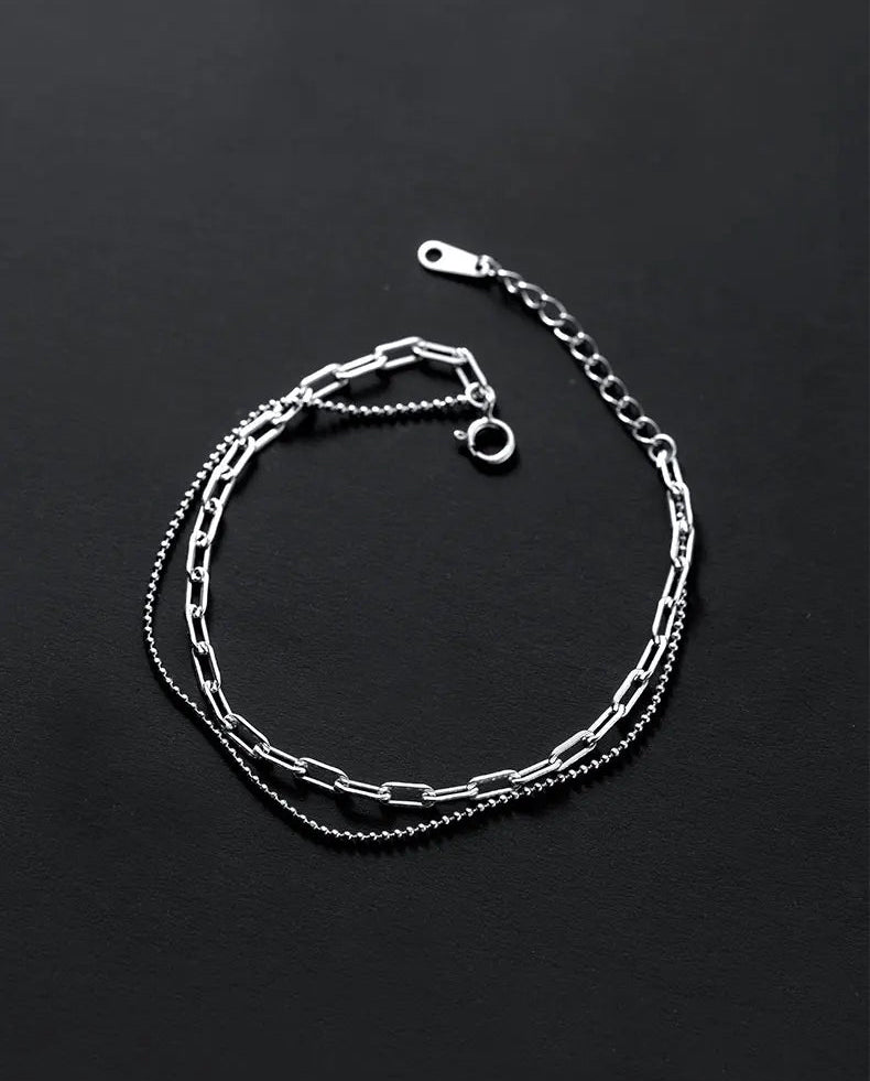 Minimalistisches zweireihiges Silberarmband mit Verlängerungskette auf schwarzem Untergrund