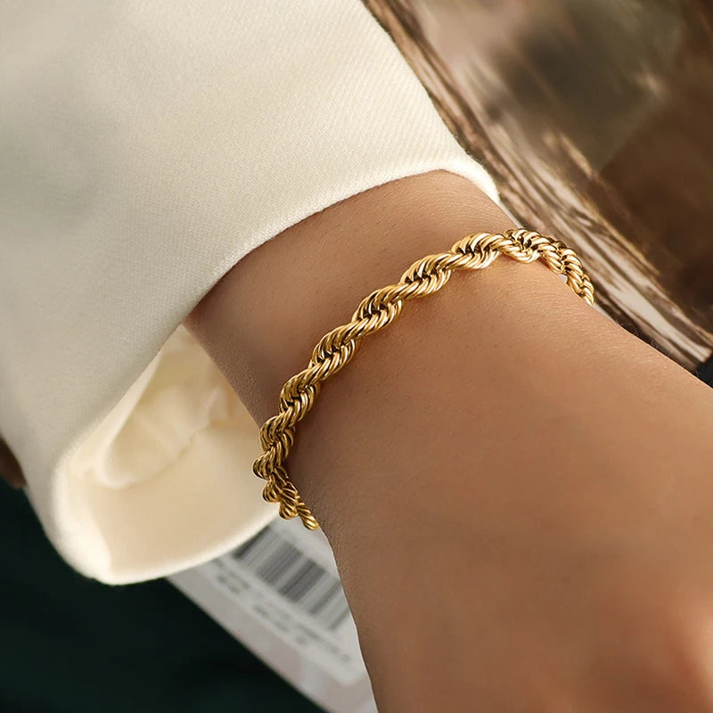 „Goldenes Kordelarmband aus Titan mit 18K Vergoldung am Handgelenk getragen, elegantes Rope Chain Design.“