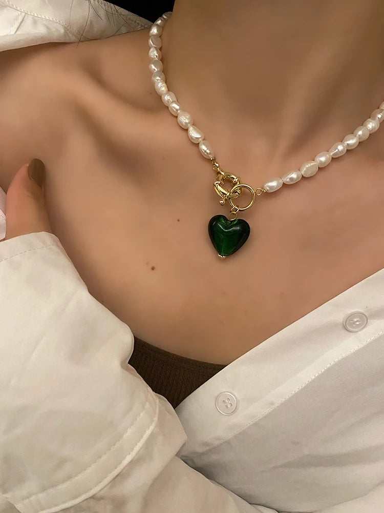 Tragestyling: Naturperlenkette mit 18K vergoldetem Knebelverschluss aus Titan und smaragdgrünem Herz-Anhänger.