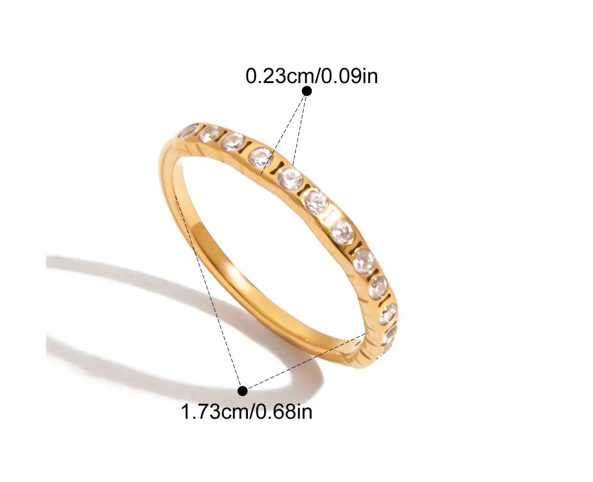 Schmaler goldener Memoirering, durchgehend besetzt mit kleinen Zirkoniasteinen. Dargestellt mit den Maßen 0.23cm (Breite) und 1.73cm (Durchmesser).