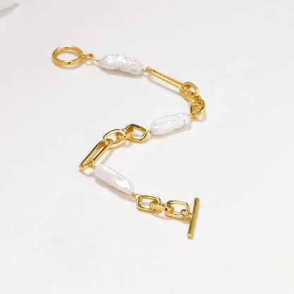 Nahaufnahme eines Gliederarmbands mit abwechselnd polierten Messing-Kettengliedern mit 18 Karat Vergoldung und schimmernden Naturperlen.