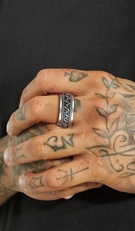 Nahaufnahme eines Mannes, der einen schmaleren silberfarbenen Edelstahl-Ring (mit leicht anderem Kettenmuster) trägt.