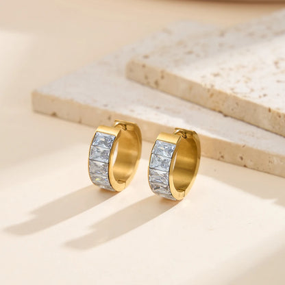 Stilvolle Produktfotografie von goldenen Edelstahl-Ohrringen mit 18K Gold und Zirkonia-Steinchen auf hellem Untergrund.