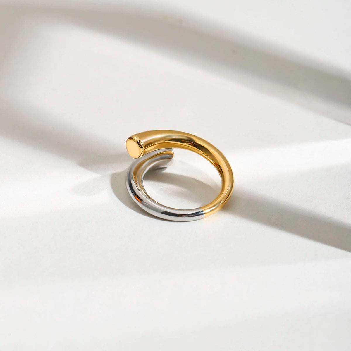 Zweifarbiger Wickelring in Gold und Silber, freigestellt auf weißem Hintergrund | moderner Edelstahlring