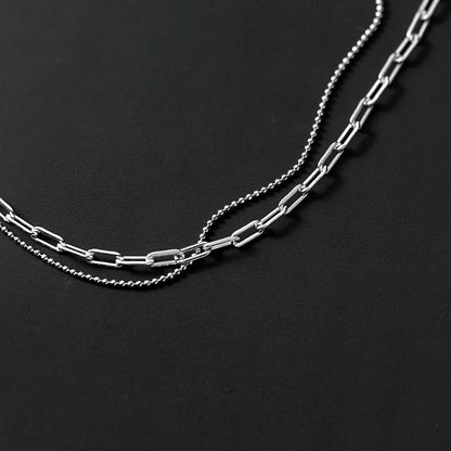 Detailansicht der beiden unterschiedlichen Kettentypen: Rechteckige Paperclip-Glieder und zarte Kugel-Kette aus platinierte Silber