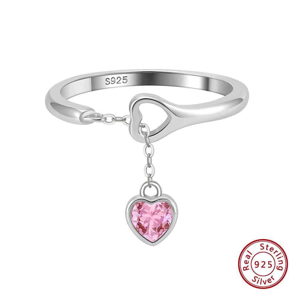 Freigestellter Ring aus 925er Sterling Silber mit hängendem rosa Herzanhänger aus Zirkonia.