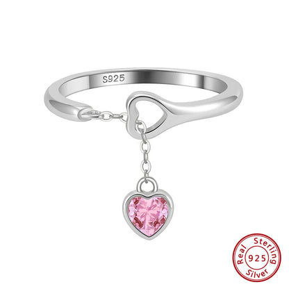 Freigestellter Ring aus 925er Sterling Silber mit hängendem rosa Herzanhänger aus Zirkonia.