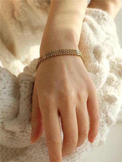 Nahaufnahme des 18K vergoldeten flachen Schlangenkette-Armbands am Handgelenk eines Models, Größenreferenz