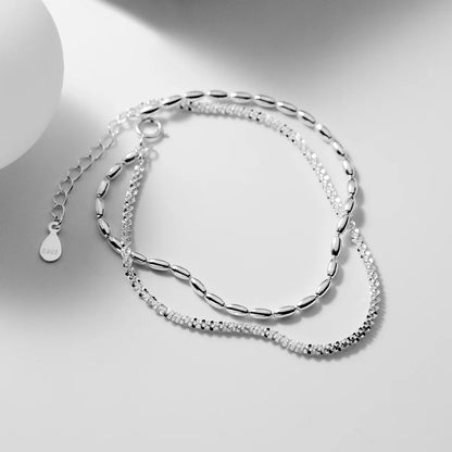 Freigestelltes zweireihiges 925 Sterling Silber Armband mit verspielter Kettenkombination auf hellem Studio-Hintergrund