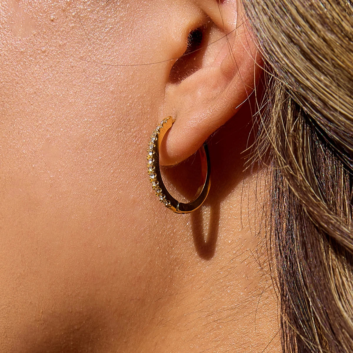 Goldschimmernde Creolen mit Zirkoniasteinen getragen | PVD 18K vergoldete Edelstahl-Hoops für Damen