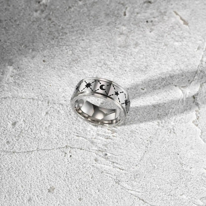 Freigestellter, silberfarbener Edelstahl-Spinner-Ring mit Sternen-Muster (andere Perspektive).