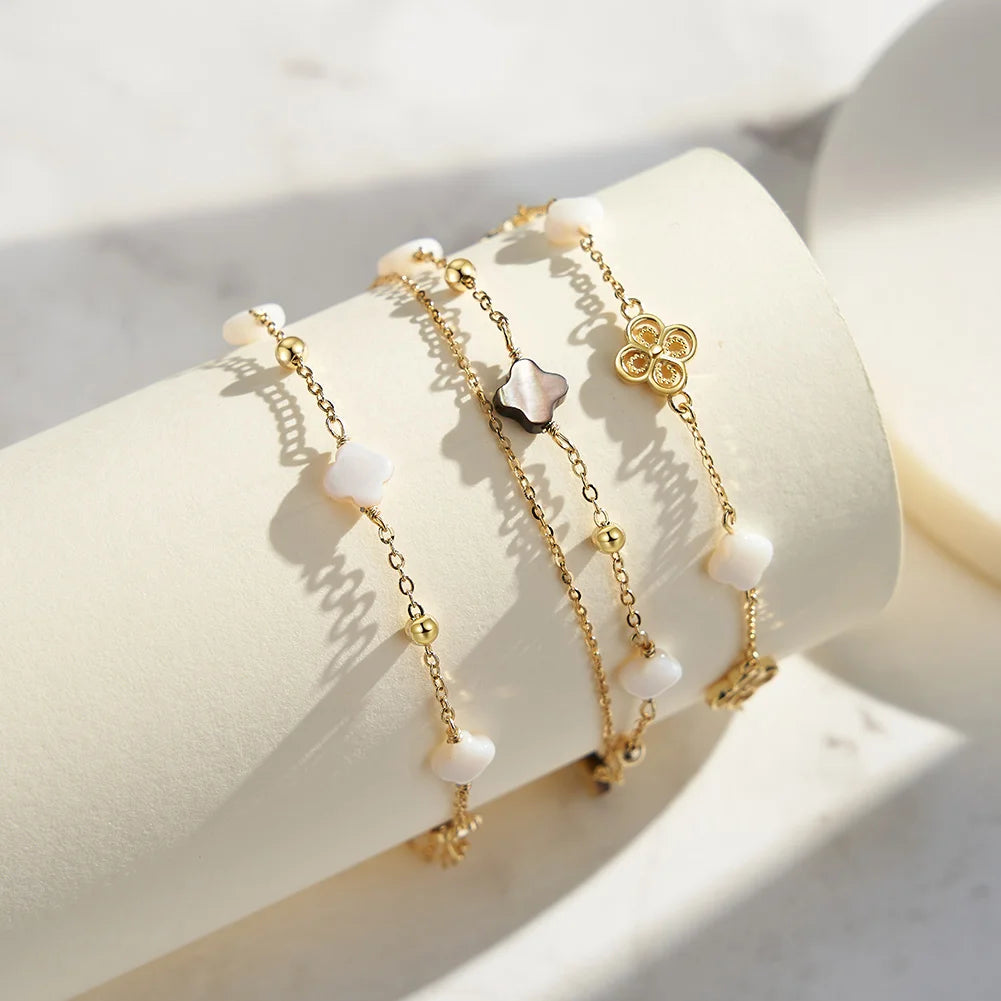 Doppeltes Gliederarmband aus 925er Sterling Silber mit weißen/beigen und schwarzen Kleeblättern,
usammen mit einem Gliederarmband aus 14K Gold vergoldetem 925er Sterling Silber mit Kleeblättern.