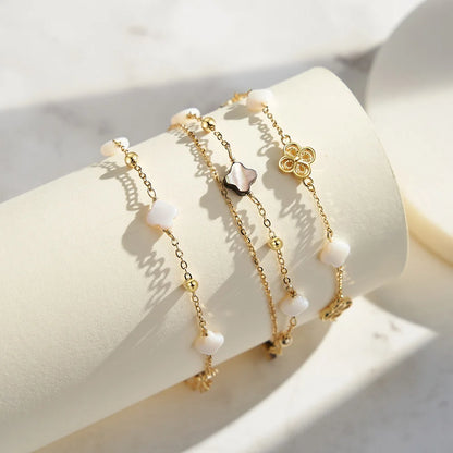 Doppeltes Gliederarmband aus 925er Sterling Silber mit weißen/beigen und schwarzen Kleeblättern,
usammen mit einem Gliederarmband aus 14K Gold vergoldetem 925er Sterling Silber mit Kleeblättern.