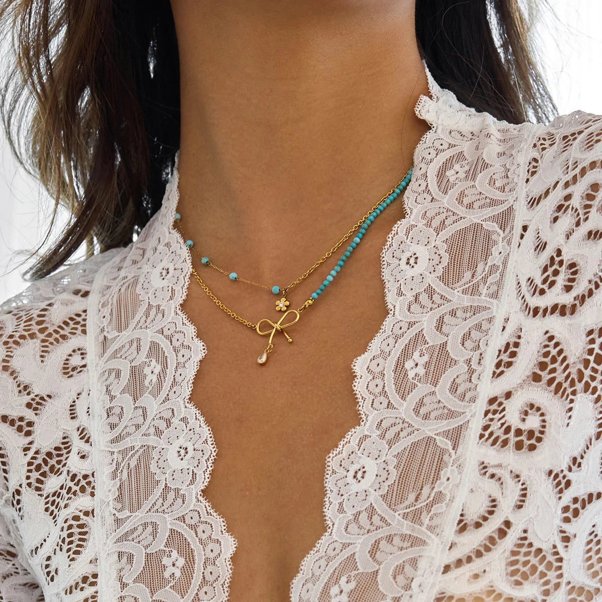 Goldene Halskette aus Edelstahl mit 18K PVD Vergoldung, türkisfarbenen Perlen und Schleifen-Anhänger