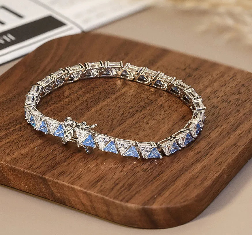 Elegantes Tennisarmband aus 925er Sterling Silber, vollständig besetzt mit quadratischen, hellblauen AAAAA Zirkonia-Steinen und einem sicheren Verschluss, präsentiert auf einem Holzbrett.