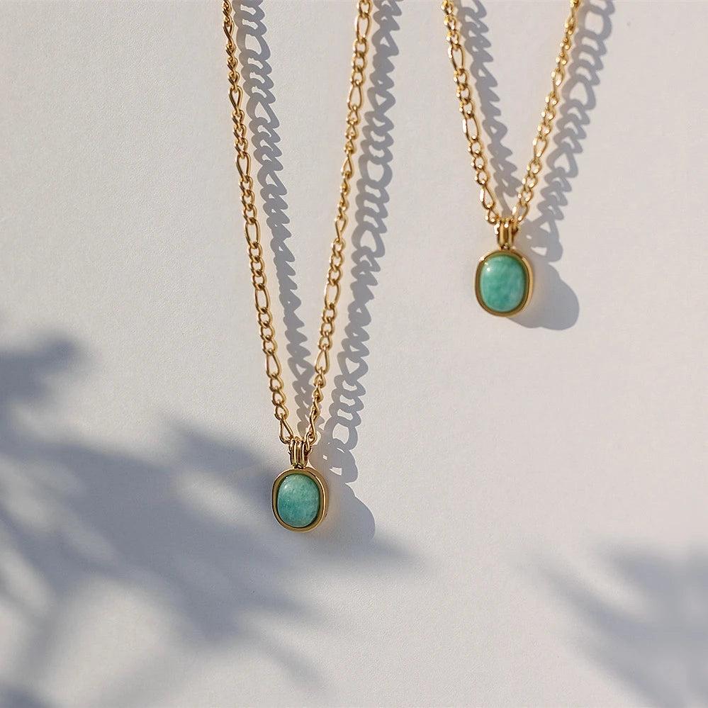 „Goldene Gliederkette aus Titan mit ovalem, türkisfarbenem Edelstein-Anhänger und 18K Vergoldung.“