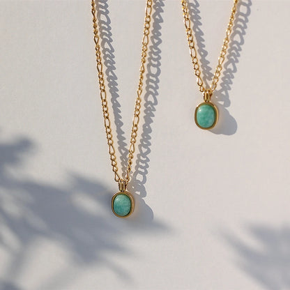 „Goldene Gliederkette aus Titan mit ovalem, türkisfarbenem Edelstein-Anhänger und 18K Vergoldung.“