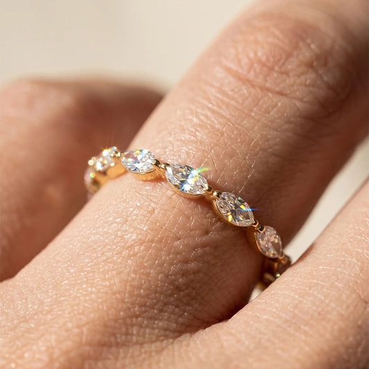 Nahaufnahme am Finger: Schmaler Memory-Ring aus 14K vergoldetem 925 Silber mit rundum verlaufenden Marquise-Zirkoniasteinen im Navette-Schliff.