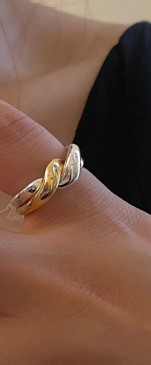 Eleganter Bicolor-Ring aus 18K vergoldetem Messing mit fließendem, ineinander verschlungenem Design in Gold und Silber.