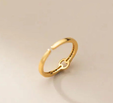 Zarter, offener Ring aus 18K vergoldetem 925er Silber mit feinen Kristallen, flach liegend mit sanftem Schattenwurf fotografiert.