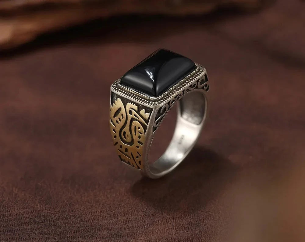 Siegelring für Männer aus 925 Sterling Silber mit schwarzem Achat-Edelstein und vergoldeten Verzierungen auf der Ringschiene.