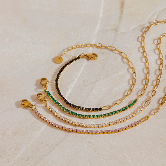 „Drei goldvergoldete Edelstahl-Armbänder dekorativ auf hellem Naturstein arrangiert – perfekt für einen eleganten, wasserfesten Alltags-Look.“