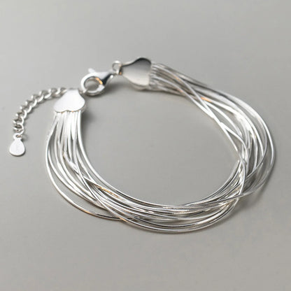 Gesamtansicht des mehrreihigen Schlangenketten-Armbands aus 925 Sterling Silber auf grauem Hintergrund